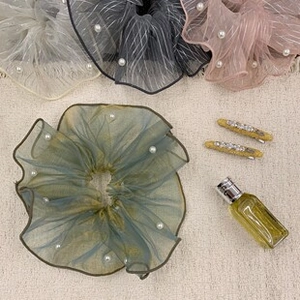 Detailed macro view of organza scrunchies with white pearls in soft Morandi colors
