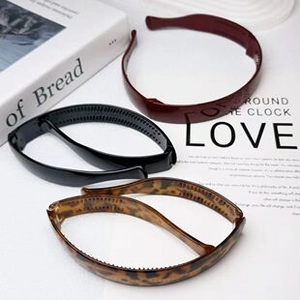 Detail of three wide headbands in black, burgundy and leopard print with non-slip teeth