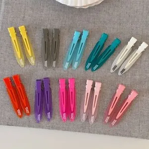 Flat lay of 20 colorful matte dopamine y2k hair clips on a grey linen background