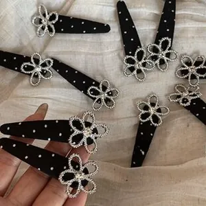 Detailed macro of black polka dot hair clip with silver rhinestone flower ornament