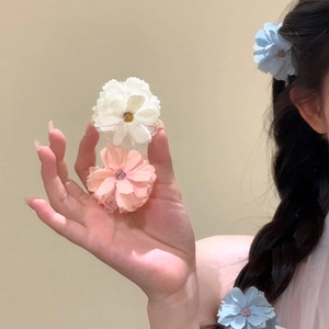 Detailed macro view of 3D layered fabric flower hair clips with clear center rhinestones