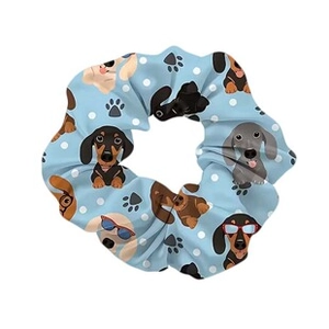 Close-up of light blue scrunchie with cartoon dachshund prints and white polka dots