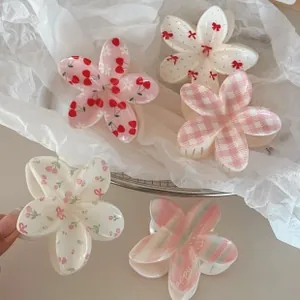 Detailed view of five floral claw clips featuring cherry, bow, and plaid patterns