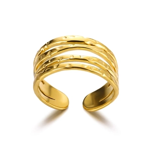 Close-up of golden adjustable ring with triple-layered bands and hammered metal texture