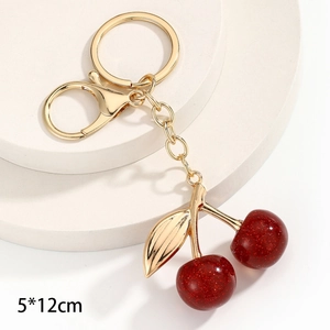 Dettaglio del portachiavi a ciliegia rossa 5x12cm con anello dorato e finitura glitter