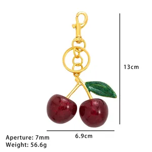 Portachiavi con ciliegie rosse brillanti, gancio dorato e foglia verde, lungo 13cm