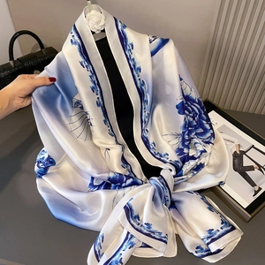 Blue and white silk scarf with floral pattern paired with elegant accessories
