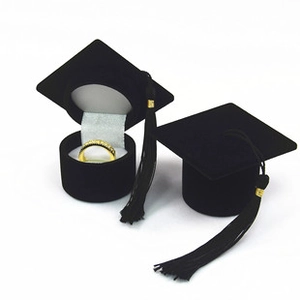 Detail of velvet graduation cap ring boxes with golden tassels and white satin lining