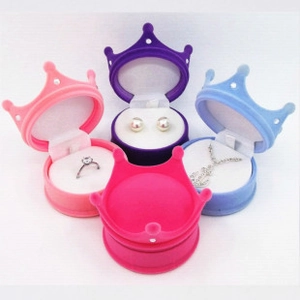 Detailed view of crown-shaped velvet jewelry boxes in pink, purple, and blue colors