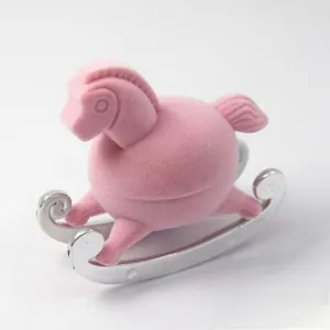 Detail view of pink flocked rocking horse jewelry box with silver metallic base
