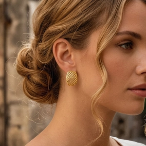 Close-up of golden mesh hollow oval stud earrings on woman showing French luxury style