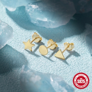Detailed view of geometric S925 sterling silver gold earrings on blue textured surface