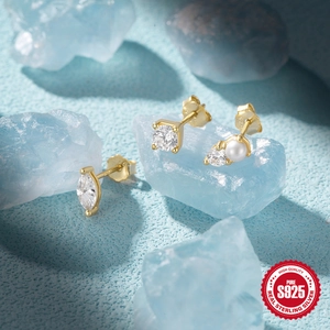 Macro shot of S925 sterling silver gold-plated stud earrings with marquise and pearl detail