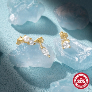 Macro detail of S925 sterling silver studs with pearl and marquise cubic zirconia