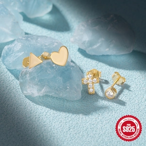 Macro shot of gold-plated S925 sterling silver heart and cross stud earring set