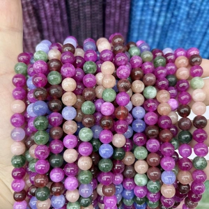 Close-up of vibrant round chalcedony beads held in hand for DIY jewelry making