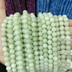 Close-up of polished light green chalcedony round beads for DIY jewelry making