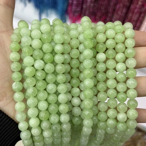 Detail of light green chalcedony round beads with a smooth semi-translucent oily luster