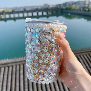 Detail of hand-inlaid pearls and rhinestones on peacock-themed stainless steel tumbler