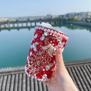 Detail of red rhinestone insulated tumbler with luxury gold peacock and pearl accents