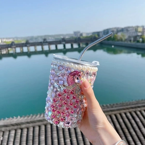 Detailed view of handmade pink crystal peacock design on straw tumbler with pearls