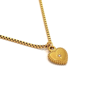 Elegant gold heart pendant necklace with starburst detail on a box chain for women