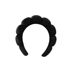 Detail view of the black padded sponge headband featuring a sleek satin finish and scalloped design