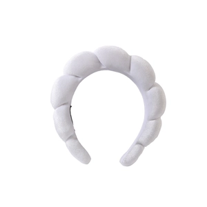 Close-up of white braided sponge headband featuring soft plush fabric and voluminous texture