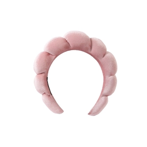 Close-up of a pink velvet sponge headband featuring soft wavy texture and premium fabric