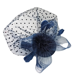 Close-up of navy blue fascinator hat with polka dot mesh veil and elegant soft feathers