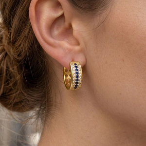 Luxurious wide gold hoop earrings with alternating blue and clear zircon gemstones