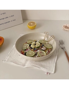 Macro detail of ceramic bowl with black ink splatter texture and fruit salad