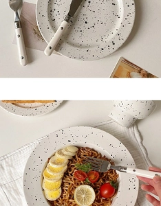 Close-up of ink splash pattern ceramic plate and bowl set with stainless steel cutlery