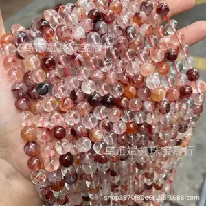 Gros plan de perles rondes en cristal de quartz rouge avec inclusions minérales