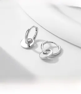 Macro shot of polished S925 sterling silver hoop earrings with small round disk charms