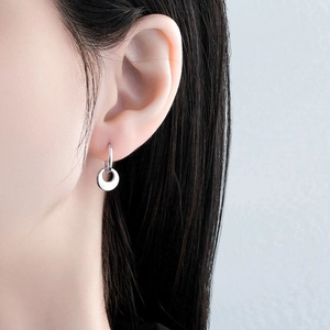 Minimalist 925 sterling silver hoop earrings with round disk pendant on female model