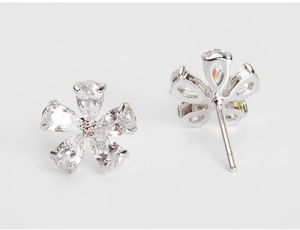 Close-up of sparkling five-petal flower earrings with pear-cut cubic zirconia stones