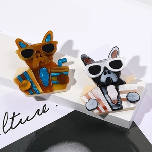 Detail of cute acrylic French Bulldog brooches with marble and shell textures in close-up