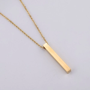 Minimalist gold bar pendant necklace in brushed stainless steel on a grey background