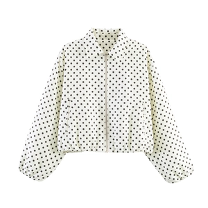 Detailed view of white jacket featuring black polka dot print and silver metal zipper closure