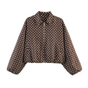 Close-up of dark brown jacket with white polka dots featuring a silver zipper closure
