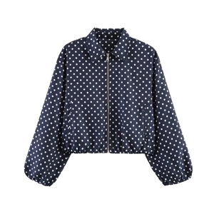 Detail of navy blue polka dot jacket featuring metal zipper and ribbed cuffs