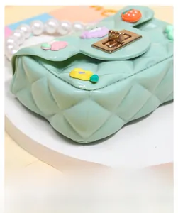 Detailed close-up of mint green mini silicone bag with DIY patches and pearl handle