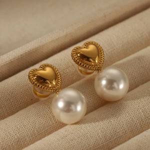Detailed view of vintage gold heart earrings with white round pearl pendants