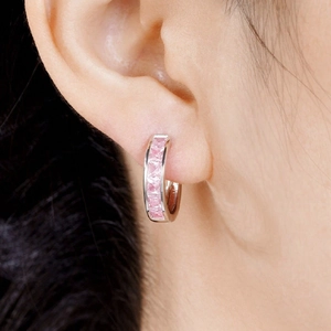 Sparkling pink square-cut gemstone huggie hoop earrings in silver metal on model ear