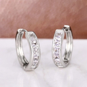 Detailed macro view of silver hoop earrings featuring square-cut sparkling cubic zirconia