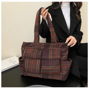 Detail of red-brown checkered winter plush tote bag with functional front flap pockets