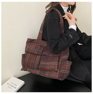 Detail view of large red plaid plush tote bag with multi-pocket design for winter