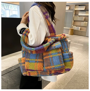 Detail view of large plush tote bag showing colorful plaid texture and side pocket
