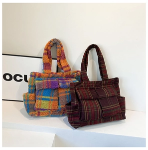 Detail of plush checkered tote bags with front pockets on a minimalist white stage